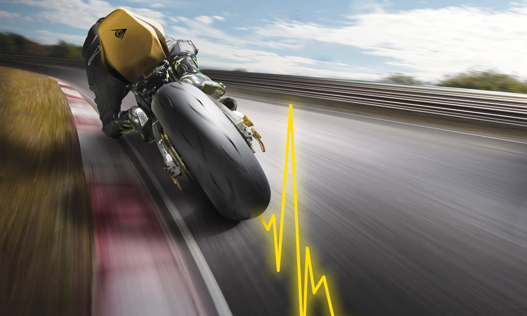 Pneumatico per hyperport Dunlop GP Racer D212 in uso su una pista con linea di impulso gialla